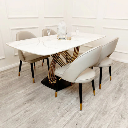 Dining table set with chairs in a room with white walls and wooden flooring.