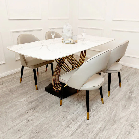 Dining table set with chairs in a room with white walls and wooden flooring.